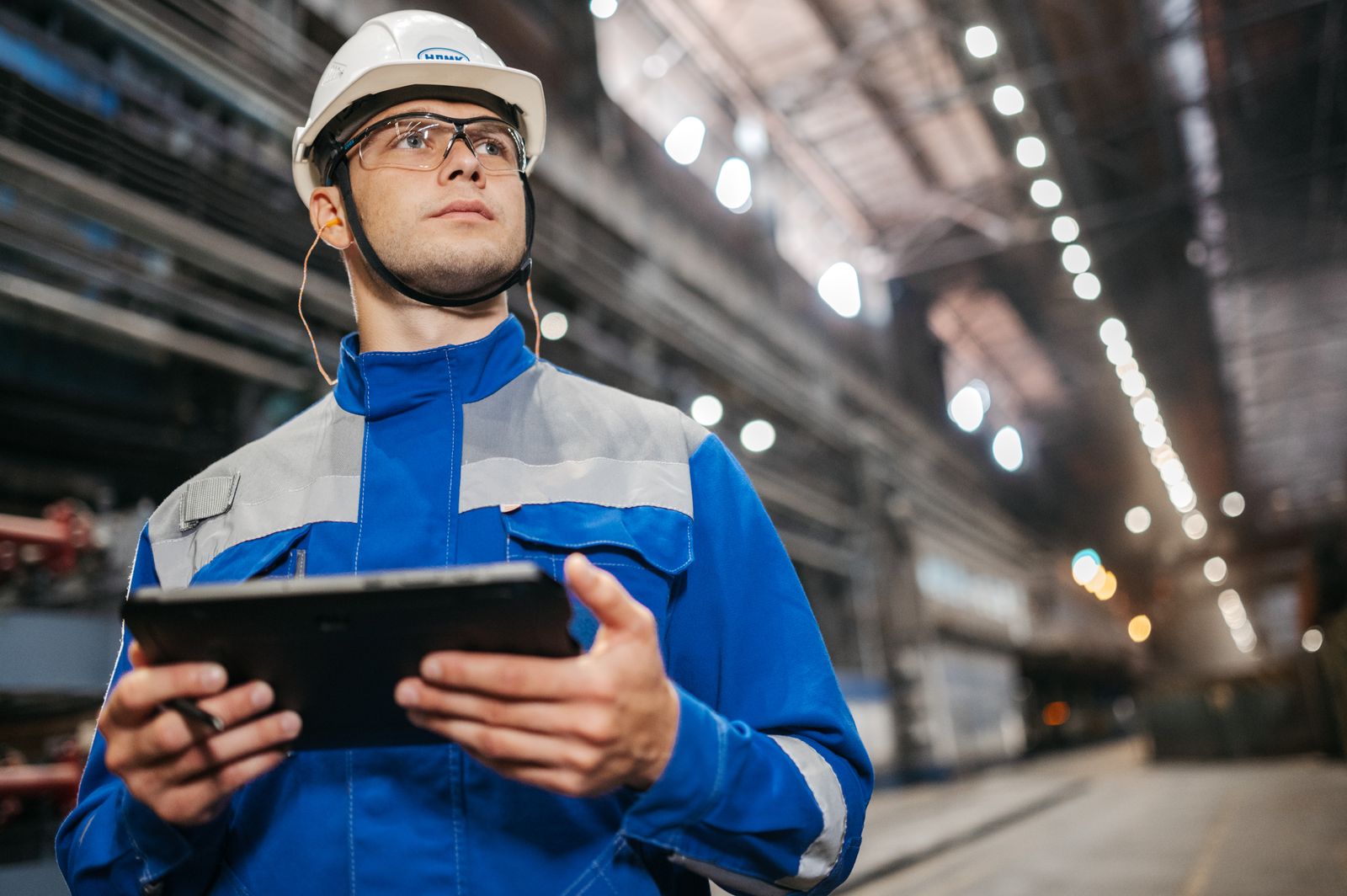 Technicien avec une tablette sur un site industriel