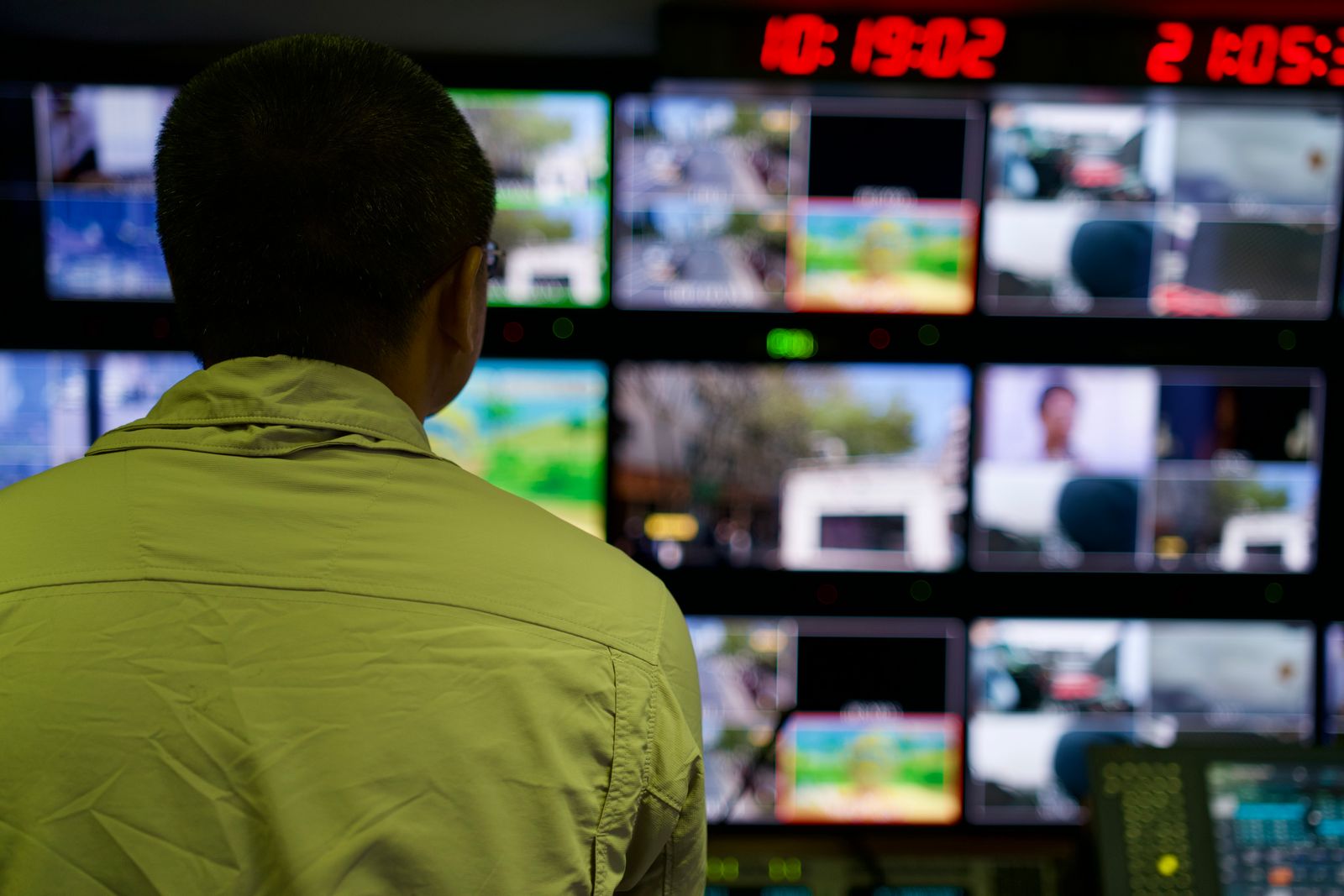 Opérateur devant un mur d’images de vidéosurveillance